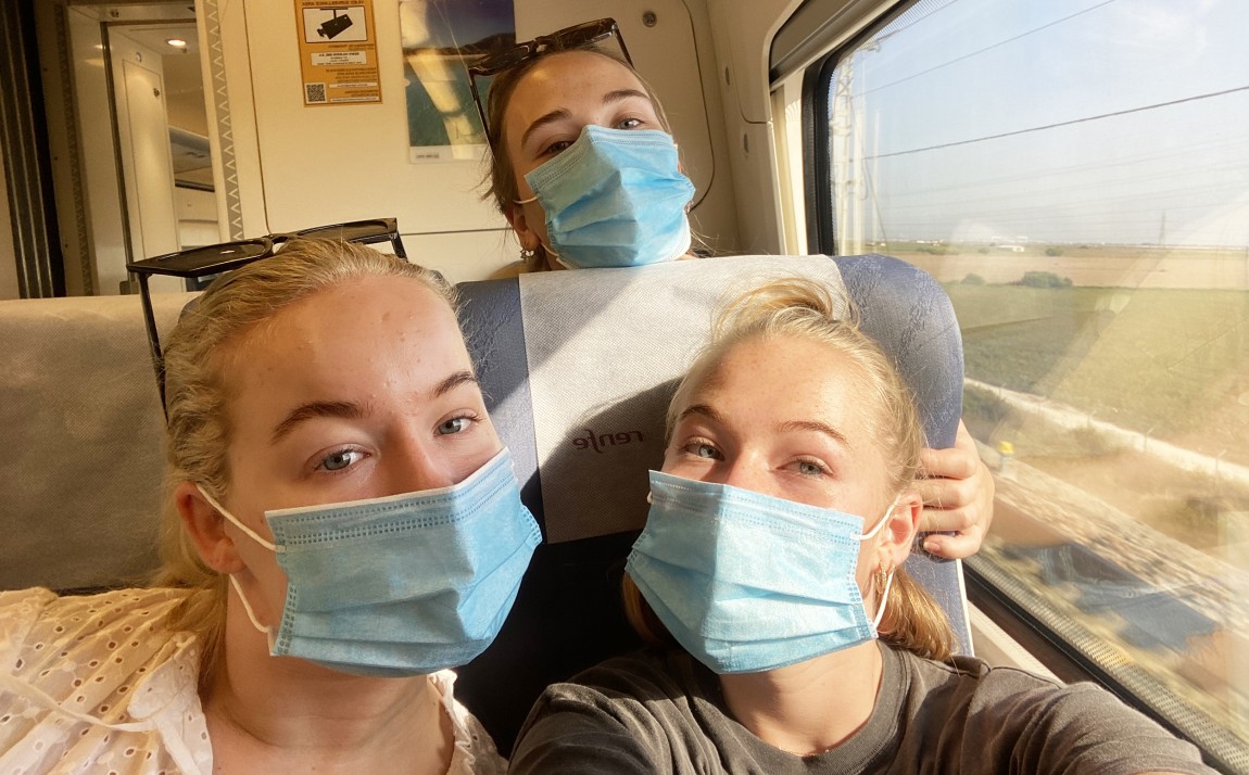Tre jenter med munnbind på togreise