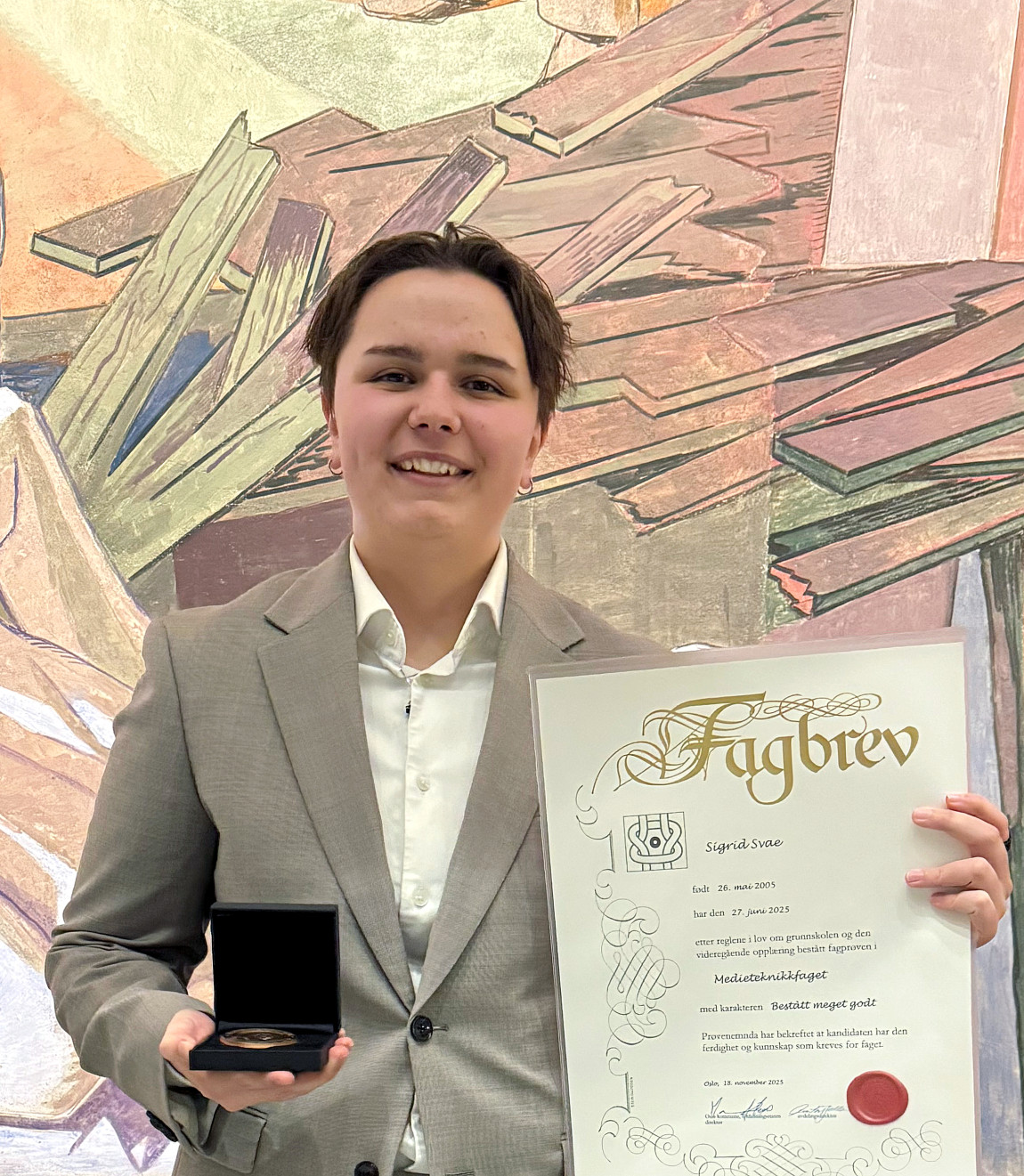 Vinner Sigrid holder opp fagbrev og fagprøvemedaljen